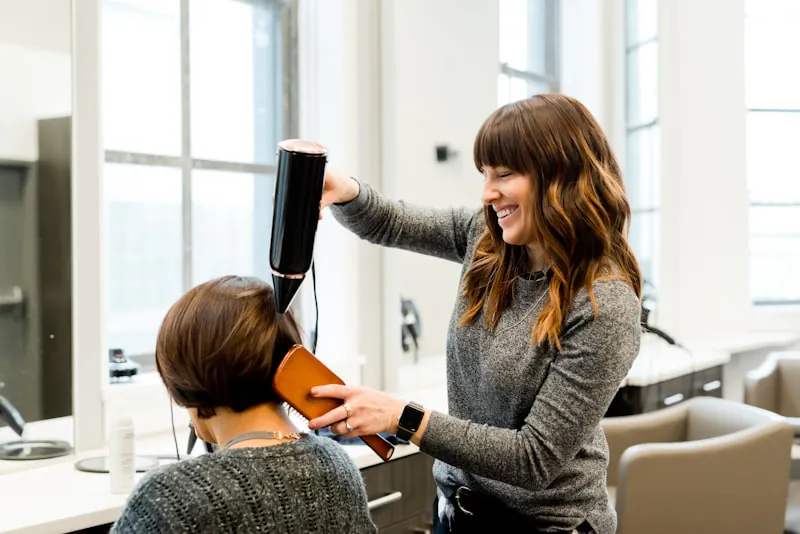 Expert stylist hands at work - precision hair colouring technique